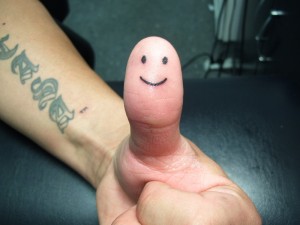 Smiley Face Tattoo on Thumb